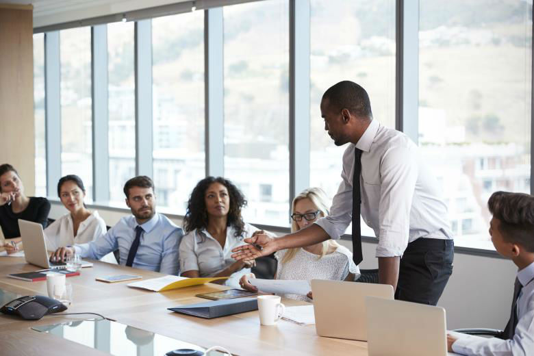 man standing to address group table.jpg